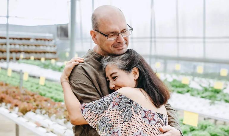 Älterer Mann umarmt eine junge Frau